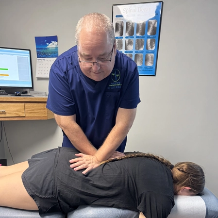 Dr. Scott Renshaw adjusting a patients mid back.