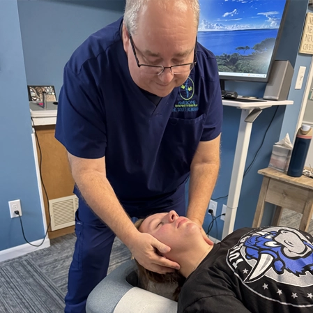 Dr. Scott Renshaw standing over a patient, adjusting their neck.